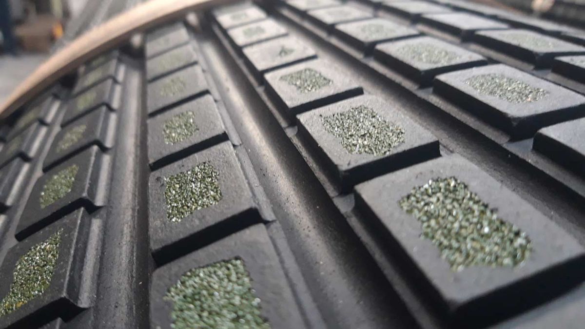 Close-up van een rubberen bekleding met vierkante noppen met keramische korrels
