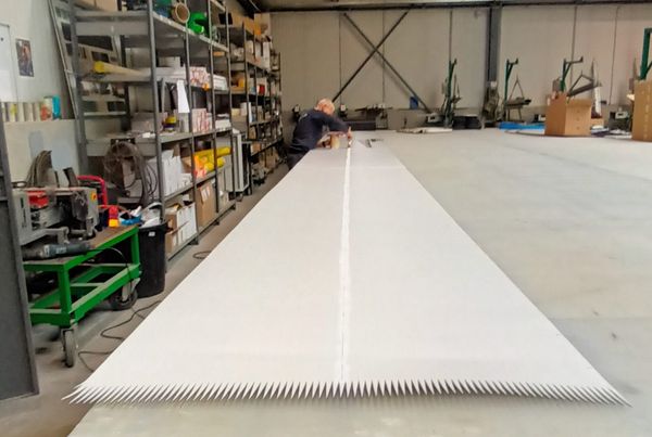 Bande PVC blanche étalée sur une table d'atelier, extrémité découpée en doigts pour la jonction
