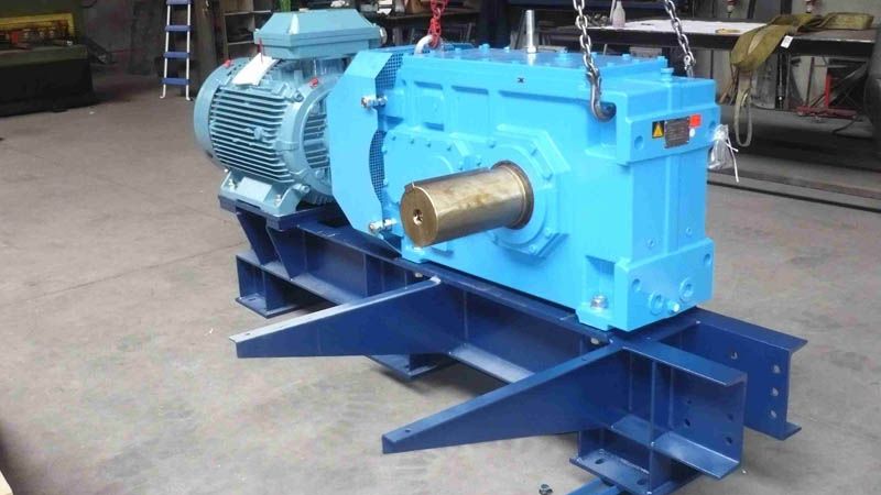 Réducteur industriel bleu et son moteur ABB montés sur une chaise (socle) en acier