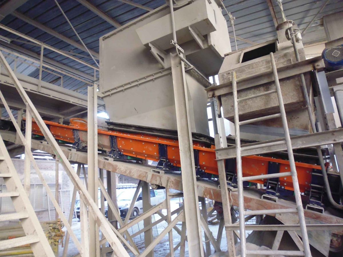 Installatie met Optim'Auge: stofdichte oranje kast onder de trechter, op de structuur van de transporteur