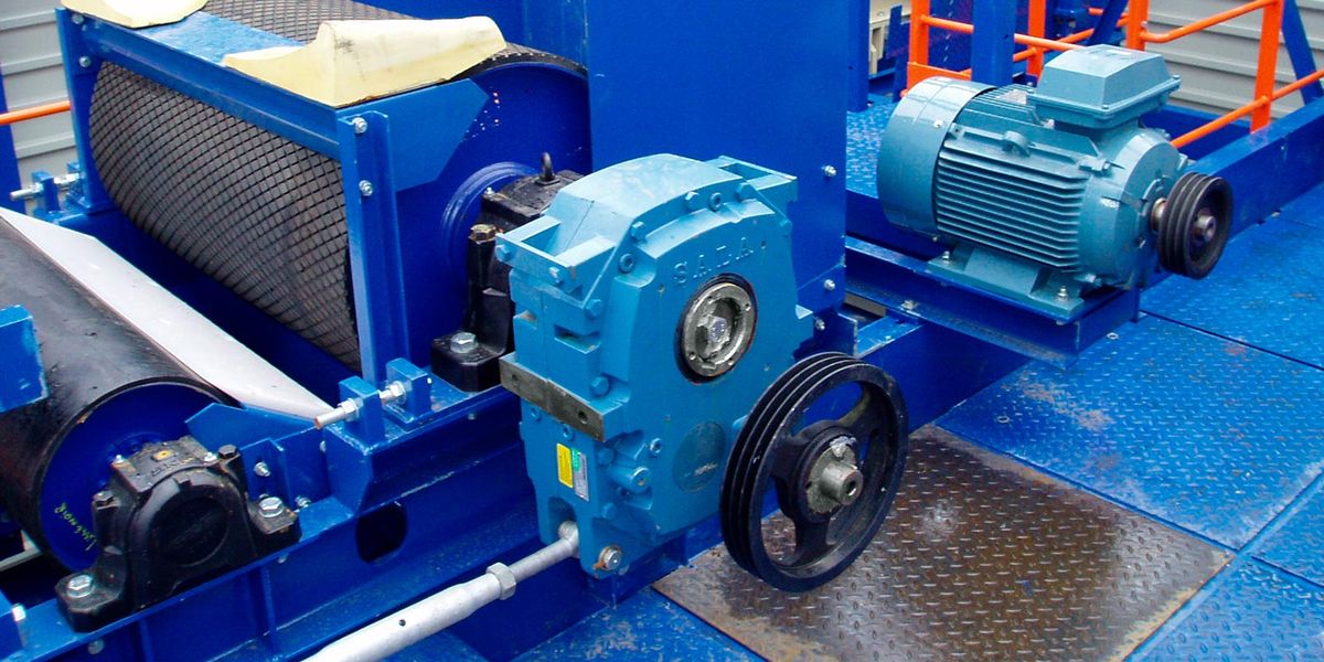 Réducteur pendulaire SALA bleu à poulie, moteur électrique et paliers sur un entraînement de convoyeur à tambour