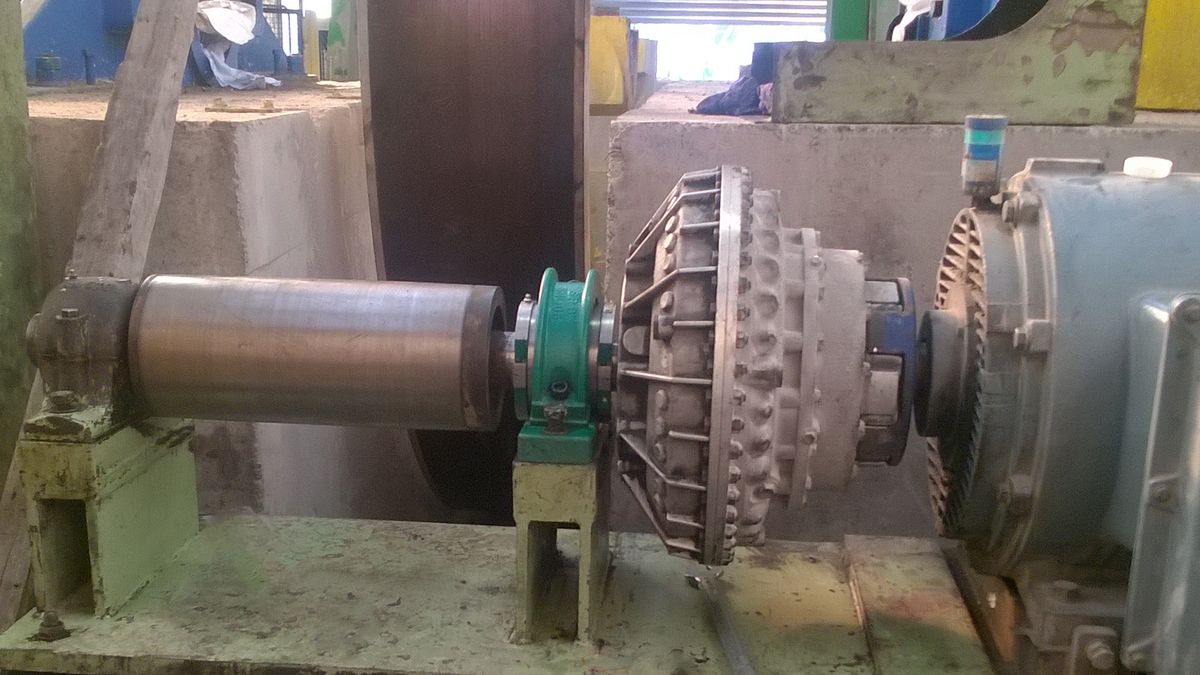 Revolvo-lager aan het uiteinde van een cilindrische as, naast een hydraulische koppeling en een elektromotor