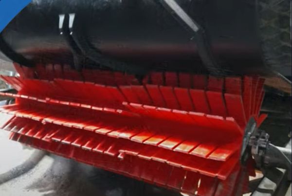 Brosse de raclage rouge à lamelles sous une bande, pour bande à chevrons