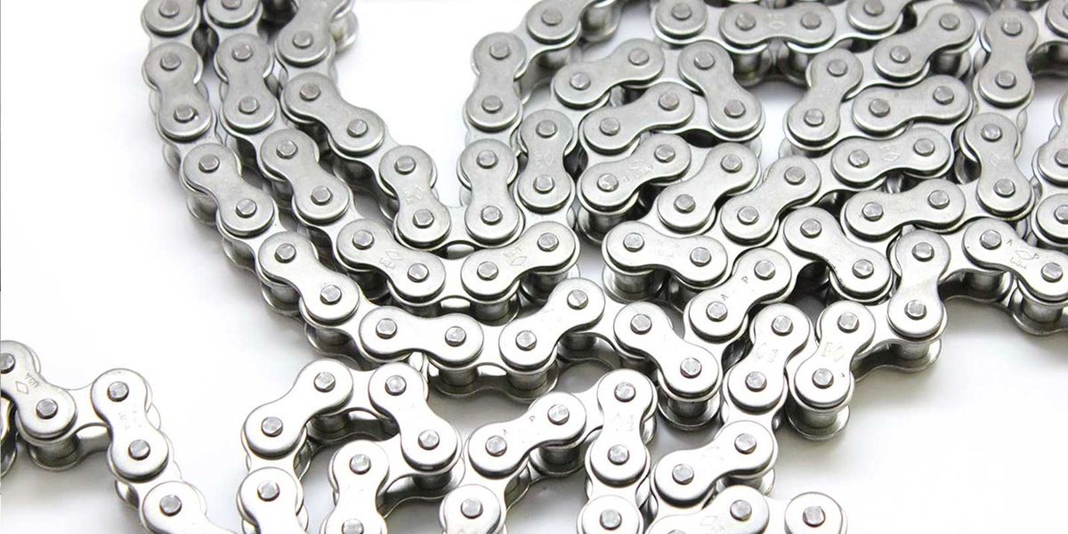 Chaîne de transmission à rouleaux DIAMOND en acier inoxydable, enroulée sur fond blanc, marquage gravé sur les plaques