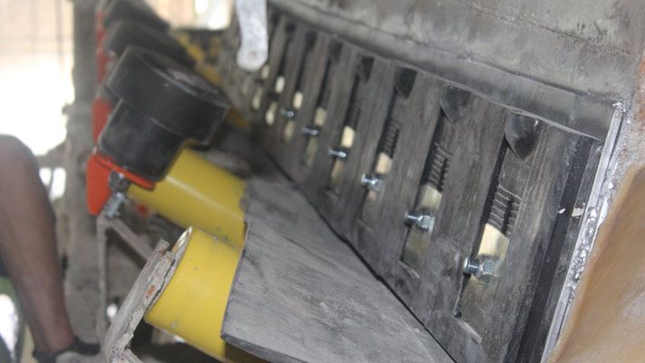Modules d'étanchéité Easy Sealing System en caoutchouc noir boulonnés sur le flanc d'un convoyeur