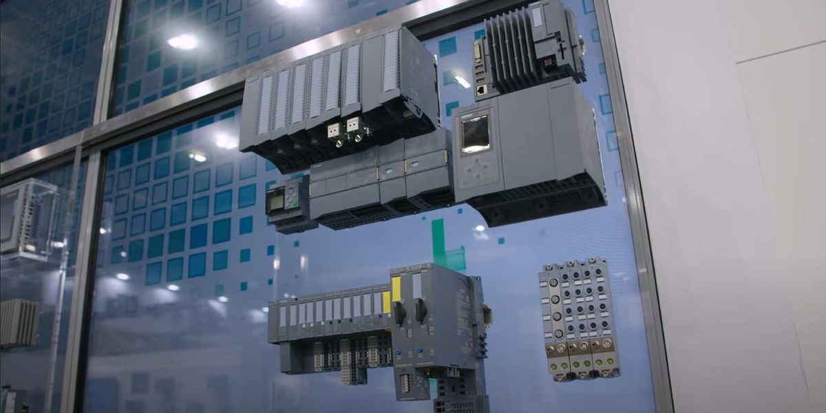 Automates programmables et modules d'entrées-sorties exposés sur une vitrine, un module marqué Siemens