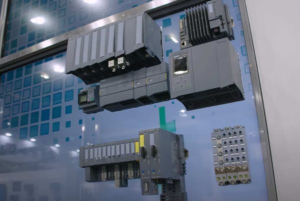 Automates programmables et modules d'entrées-sorties exposés sur une vitrine, un module marqué Siemens