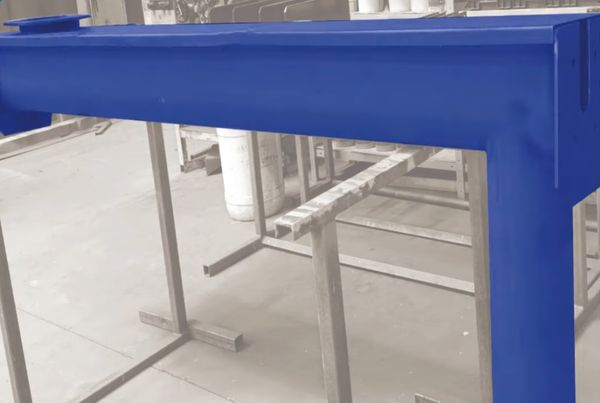 Poutre en acier peinte en bleu vif sur supports, dans un atelier de construction métallique