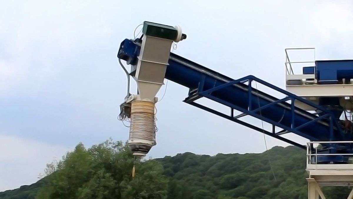 Manchette télescopique suspendue sous une goulotte de chargement en bout de convoyeur incliné