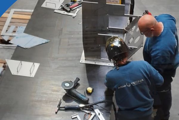 Deux techniciens ABM TECNA soudent une pièce de tôlerie sur un établi