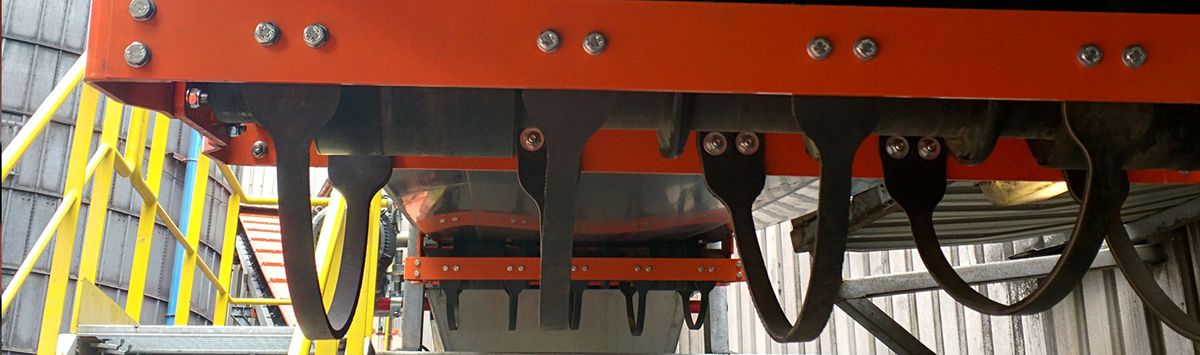 Zwarte vangbanden van de Optim’Protec-RI-SR onder een oranje frame, boven een looppad met gele leuning