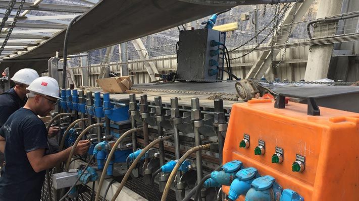 Technici bereiden een vulkanisatiepers voor om een transportband ter plaatse te verbinden