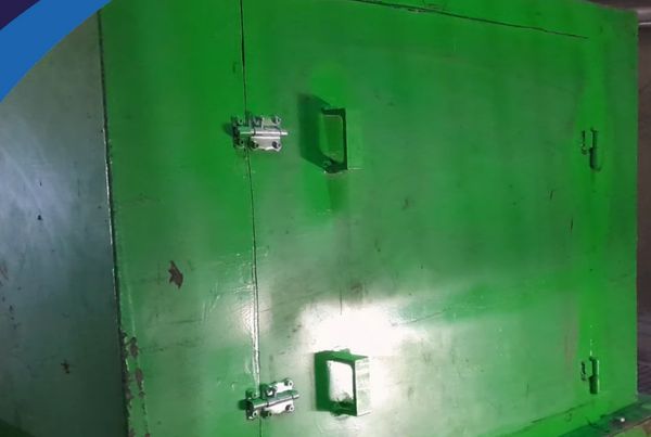 Porte d'accès verte à deux poignées et deux verrous sur un caisson de convoyeur, zone du racleur
