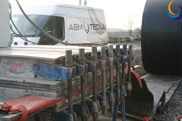 Presse de vulcanisation serrée par des brides sur une bande transporteuse, camionnette ABM TECNA à l'arrière