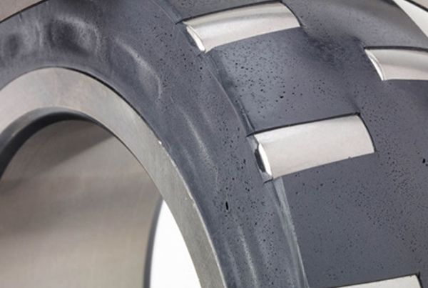 Gros plan d'un roulement à rouleaux dont l'espace libre est rempli de lubrifiant solide noir Solid Lube