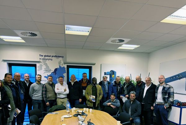 Photo de groupe de l'équipe de Heidelberg Materials Wallonie en visite dans la salle de réunion d'ABM TECNA à Fleurus